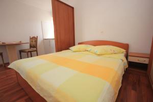 a bedroom with a colorful bed with a desk and a chair at Studio Pasman 8215a in Pašman