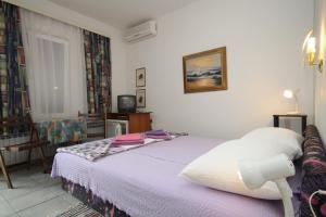 a bedroom with a bed and a table and a chair at Double Room Mali Losinj 7953a in Mali Lošinj