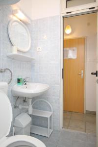 a bathroom with a sink and a toilet and a mirror at Double Room Mali Losinj 7953a in Mali Lošinj