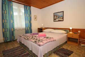 a bedroom with a bed and a table and a window at Apartments and rooms by the sea Mali Losinj (Losinj) - 7953 in Mali Lošinj