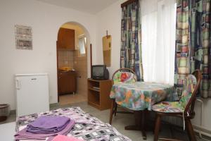 a room with a table and a chair and a kitchen at Apartments and rooms by the sea Mali Losinj (Losinj) - 7953 in Mali Lošinj
