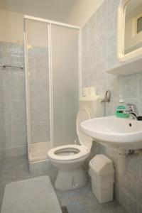 a bathroom with a toilet and a sink and a shower at Apartments and rooms by the sea Mali Losinj (Losinj) - 7953 in Mali Lošinj