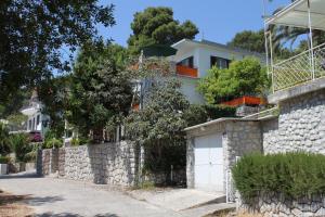 a house with a stone wall and a garage at Studio Mali Losinj 7953a in Mali Lošinj