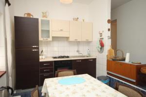 una piccola cucina con tavolo e frigorifero di Seaside holiday house Verunic, Dugi otok - 8126 a Veli Rat