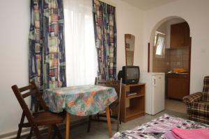 a living room with a table and a small kitchen at Studio Mali Losinj 7953a in Mali Lošinj