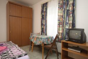 a small room with a table and a tv at Studio Mali Losinj 7953a in Mali Lošinj