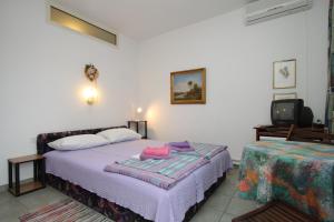 a bedroom with a bed and a tv at Double Room Mali Losinj 7953b in Mali Lošinj