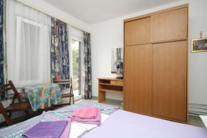 a bedroom with a bed and a wooden cabinet at Double Room Mali Losinj 7953b in Mali Lošinj