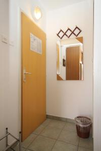 a bathroom with a brown door and a mirror at Double Room Mali Losinj 7953b in Mali Lošinj
