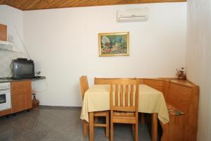 a kitchen with a table and chairs and a tv at Apartments with a parking space Mali Losinj (Losinj) - 8059 in Mali Lošinj