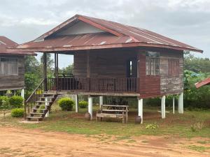 duży drewniany dom ze schodami i werandą w obiekcie Lek's Issan Home and Travel w mieście Ban Kut Khaen