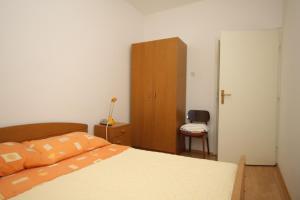 Schlafzimmer mit einem Bett und einem Holzschrank in der Unterkunft Apartment Savar 8127b in Savar