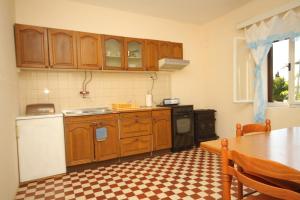 a kitchen with wooden cabinets and a table in it at Apartment Savar 8127b in Savar