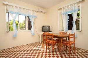 a dining room with a table and chairs and a tv at Apartment Savar 8127b in Savar