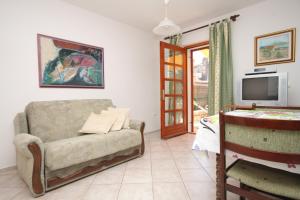 uma sala de estar com um sofá e uma televisão em Apartments by the sea Osor, Losinj - 8088 em Nerezine