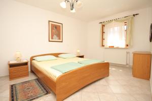 a bedroom with a large bed and a window at Apartments by the sea Osor, Losinj - 8088 in Nerezine