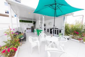 a patio with a table and chairs and an umbrella at Hostal Casa Dandy in Cartagena de Indias