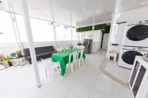 a living room with a green table and a washing machine at Hostal Casa Dandy in Cartagena de Indias