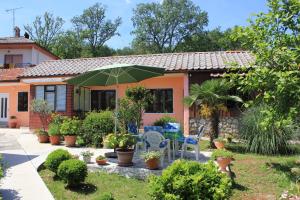 dom z patio z zielonym parasolem w obiekcie Apartment Opric 7716b w mieście Lovran