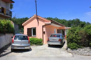 dwa samochody zaparkowane przed domem w obiekcie Apartment Opric 7716b w mieście Lovran +11 zdjęć