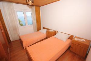 two beds in a small room with a window at Apartments by the sea Zaglav, Dugi otok - 8191 in Sali