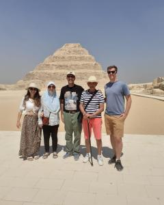 un gruppo di persone che si trovano di fronte alla piramide di Kenzy guest house a Il Cairo