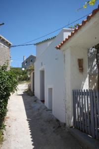 un callejón entre dos edificios blancos con una valla en Seaside holiday house Unesic - Unije, Losinj - 8045, en Unije