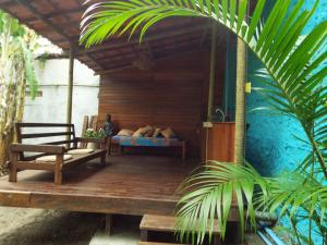 Pokój z łóżkiem i krzesłem na ganku w obiekcie JARDIM UXUA w mieście Ilha de Boipeba