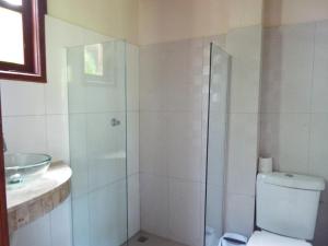 a bathroom with a shower and a toilet and a sink at JARDIM UXUA in Ilha de Boipeba
