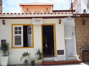 mały biały dom z znakiem na drzwiach w obiekcie JARDIM UXUA w mieście Ilha de Boipeba