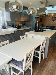 una cocina con mesa blanca y sillas. en Hameway House- Stunning 4 bedroom house with a spacious kitchen en Londres