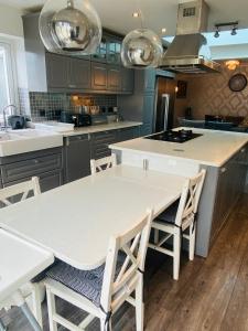 una cocina con mesa blanca y sillas. en Hameway House- Stunning 4 bedroom house with a spacious kitchen, en Londres