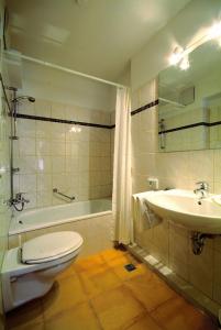 y baño con aseo, lavabo y bañera. en Traveller Hotel en Lübeck
