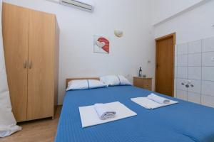 - une chambre avec un lit bleu et des serviettes dans l'établissement Apartment Podaca 6677d, à Podaca