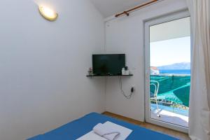 a room with a bed and a tv and a balcony at Apartment Podaca 6677d in Podaca