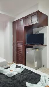 a room with a bed with a tv and a refrigerator at Hotel Dorado BAQ in Barranquilla