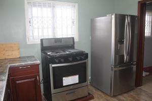 a kitchen with a stove and a refrigerator at Coast to Coast Vacation Home in Winneba