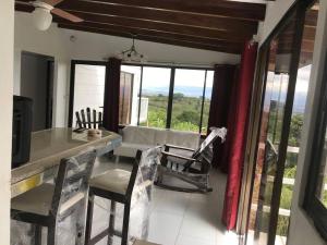 a living room with a table and chairs and windows at Casa Panorámica con Jacuzzi balcon. Familia Amigos in Robles