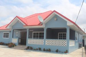 a blue house with a red roof at Coast to Coast Vacation Home in Winneba