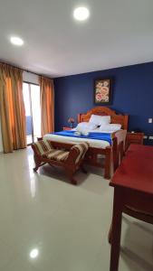 1 dormitorio con 2 camas y pared azul en Hotel Dorado Barranquilla, en Barranquilla