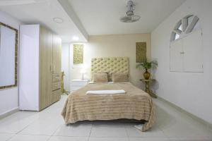 1 dormitorio con 1 cama grande en una habitación blanca en Apartamento en Casa Dandy, en Cartagena de Indias