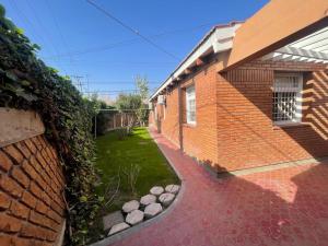 a brick house with a walkway next to a yard at Morada Luminosa - San Juan, Capital in San Juan