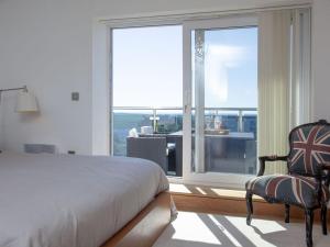 a bedroom with a bed and a large window at The Penthouse - Clearview in Newquay