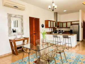 uma sala de jantar e cozinha com uma mesa de vidro e cadeiras em Apartamento en el Corazón de Casco Viejo Panamá 10 na Cidade do Panamá