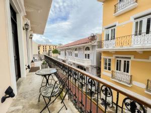 a balcony with a table and chairs and buildings at Apartamento en el Corazón de Casco Viejo Panamá 10 in Panama City