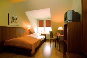 a bedroom with a bed and a tv and a desk at Traveller Hotel in Lübeck