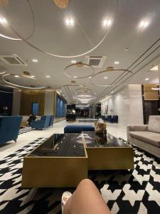 Un vestíbulo con un sofá, una mesa y sillas. en Minimalist Cozy Condo Studio Unit in Grand Residences Cebu, en Cebú