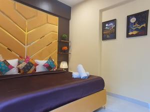 a bedroom with a bed with a large headboard at OSI Apartments Lilavati Bandra in Mumbai