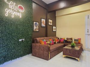 a living room with a couch and a green wall at OSI Apartments Lilavati Bandra in Mumbai