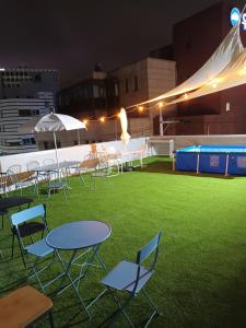 un groupe de chaises et de tables sur un toit de nuit dans l'établissement Elephant Hostel Nampo, à Busan